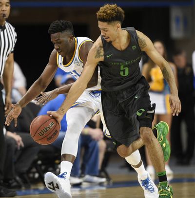 Oregon guard Tyler Dorsey, right, battles UCLA guard Prince Ali for the loose ball during the first half  Wednesday. (Kelvin Kuo / Associated Press)