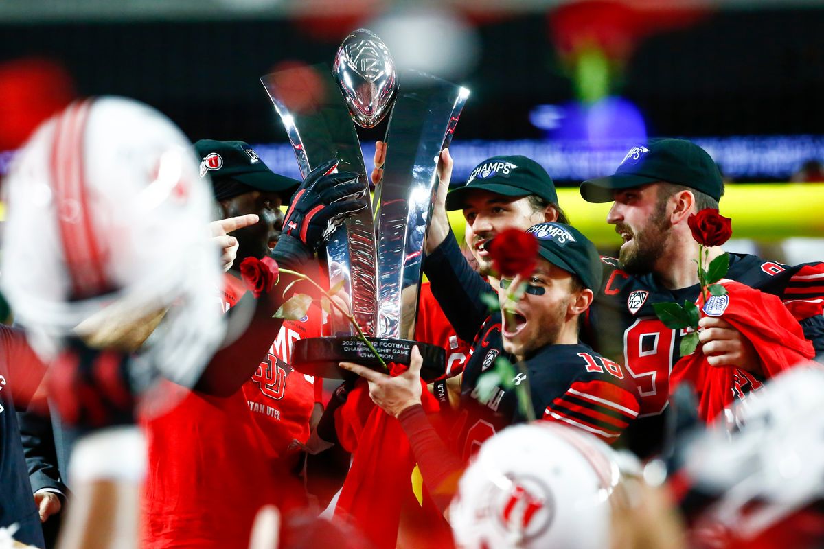 FILE - Utah players celebrate with the trophy after their victory over Oregon to win the Pac-12 Conference championship NCAA football game Friday, Dec. 3, 2021, in Las Vegas. The Pac-12 announced, Wednesday, May 18, 2022, it was scrapping its divisional format for the coming season Wednesday, May 18, 2022.  (Chase Stevens)