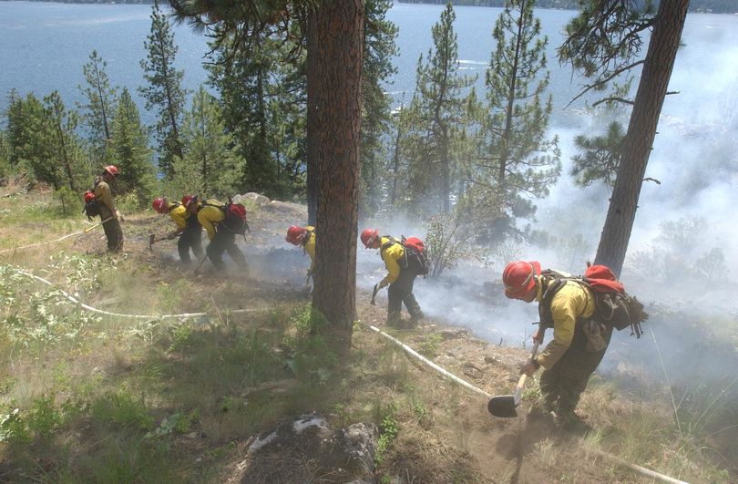 Idaho Department of Lands firefighters dig firelines on the eastern edge of a wildfire in June 2003 on a Tubbs Hill hillside above Lake Coeur d'Alene. It was possibly started by fireworks. (Jesse Tinsley / The Spokesman-Review)