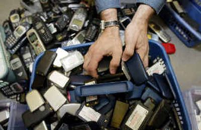 
A worker at CollectiveGood in Tucker, Ga., sorts through old cell phones and cell phone batteries for recycling. 
 (The Spokesman-Review)