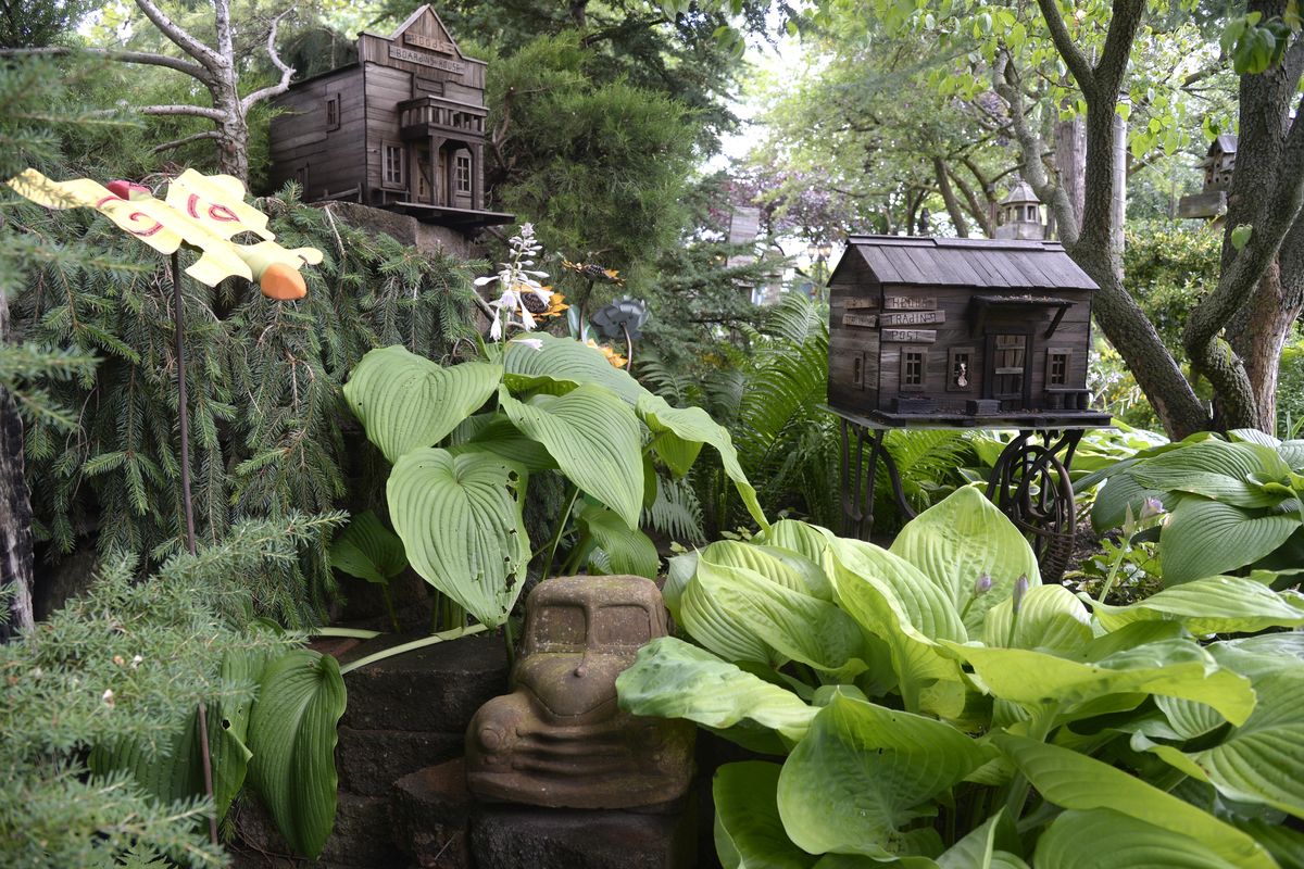 Ed and Tina Hood have designed humorous, whimsical and historical scenes, like this display of railroad and street signs, throughout their acre of garden at their home in Dalton Gardens. The home will be on the upcoming Coeur d