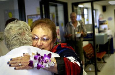 
Postmaster Milly Cropp receives a goodbye hug during her retirement party Friday at the Otis Orchards Post Office where she worked for 30 years. 
 (Brian Plonka / The Spokesman-Review)