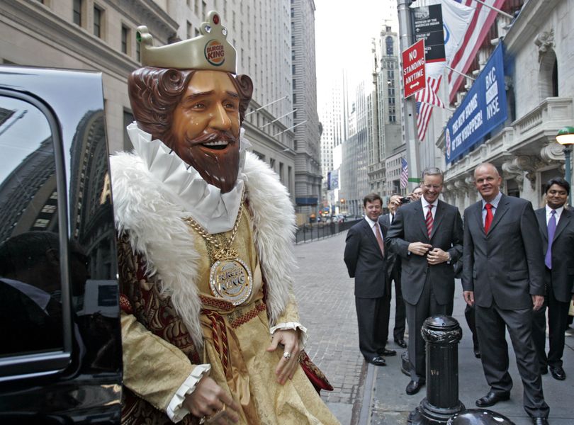 Burger King CEO John W. Chidsey, background center, watches as “The King” – the mascot of Burger King Corp. – arrives at the New York Stock Exchange in New York in 2006. (Associated Press)