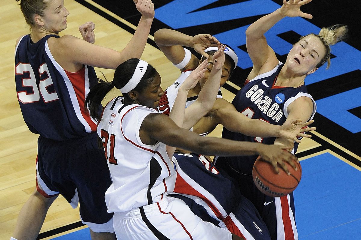 The bodies collide under the basket as Kelly Bowen of Gonzaga, right, and Kayla Standish, far left, battle the Louisville post players during the first half. (Christopher Anderson)