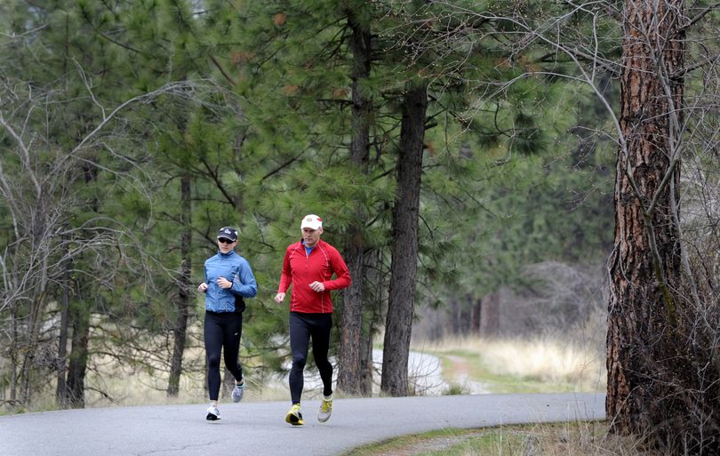 Rachel and Eric Johnson jog down the Centennial Trail in Spokane Valley in preparation for an Ironman race. (Jesse Tinsley)