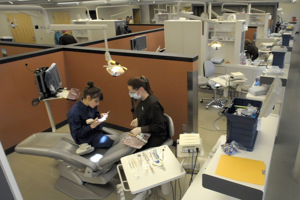 Dental program students Emily Cooper, left, and Sarah Chase work at one of the 46 stations in the dental clinic Friday. (Christopher Anderson / The Spokesman-Review)