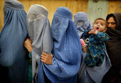 
Afghan women wearing traditional burka stand in line as they wait to vote in the presidential election Saturday at the Lamae Shaheed Girls High School in Kabul, Afghanistan. 
 (Associated Press / The Spokesman-Review)