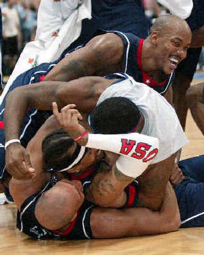
Teammates pile on Allen Iverson after his 3-pointer lifted Team USA past Germany. 
 (Associated Press / The Spokesman-Review)