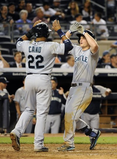 Robinson Cano greets M’s teammate Kyle Seager, whose 3-run homer in the ninth capped a big game. (Associated Press)