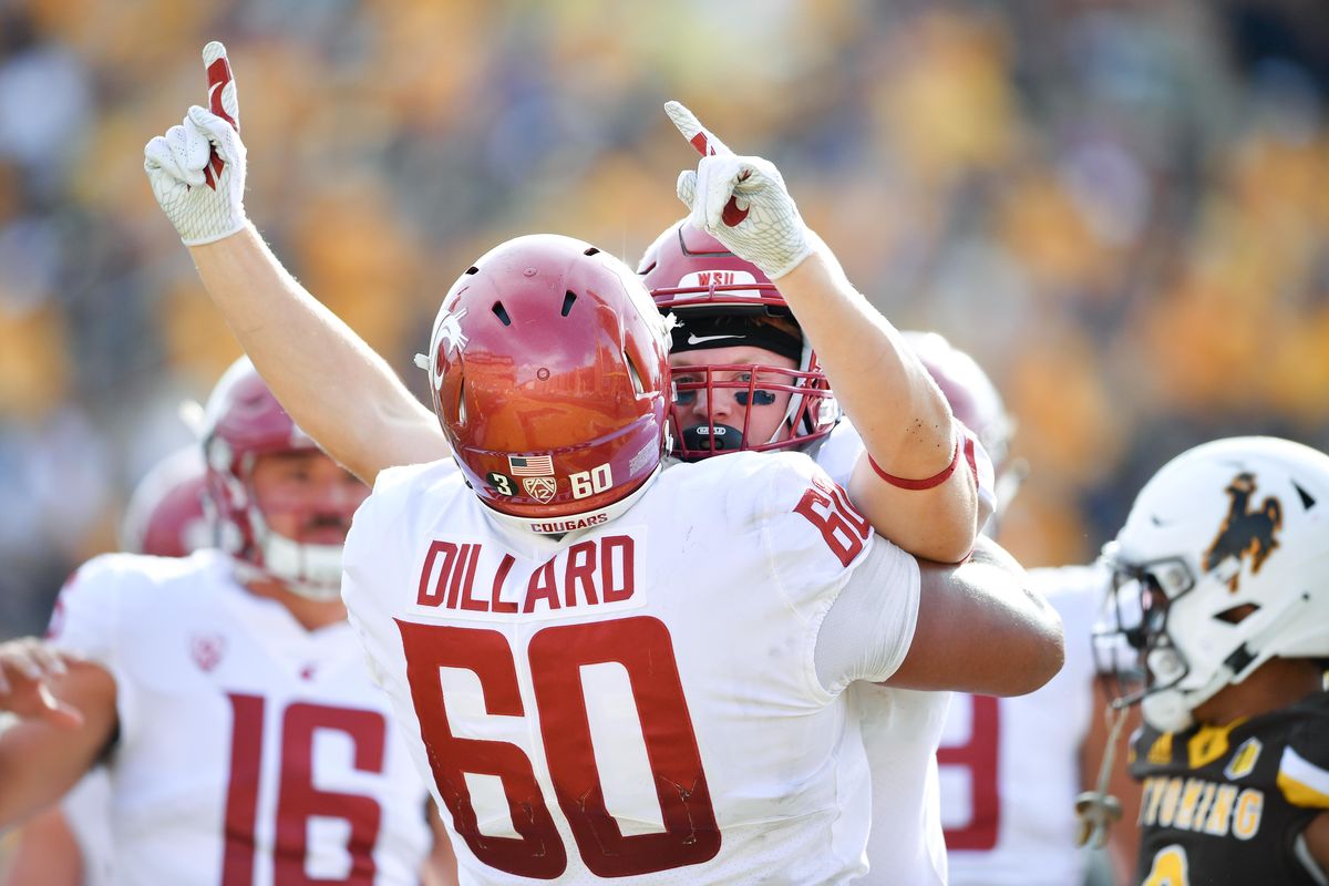 Washington State Cougars running back Max Borghi (21) reacts with Washington State Cougars offensive lineman Andre Dillard (60) after scoring a touchdown against Wyoming during the second half of a college football game on Saturday, September 1, 2018, at War Memorial Stadium in Laramie, Wyo. (Tyler Tjomsland / The Spokesman-Review)