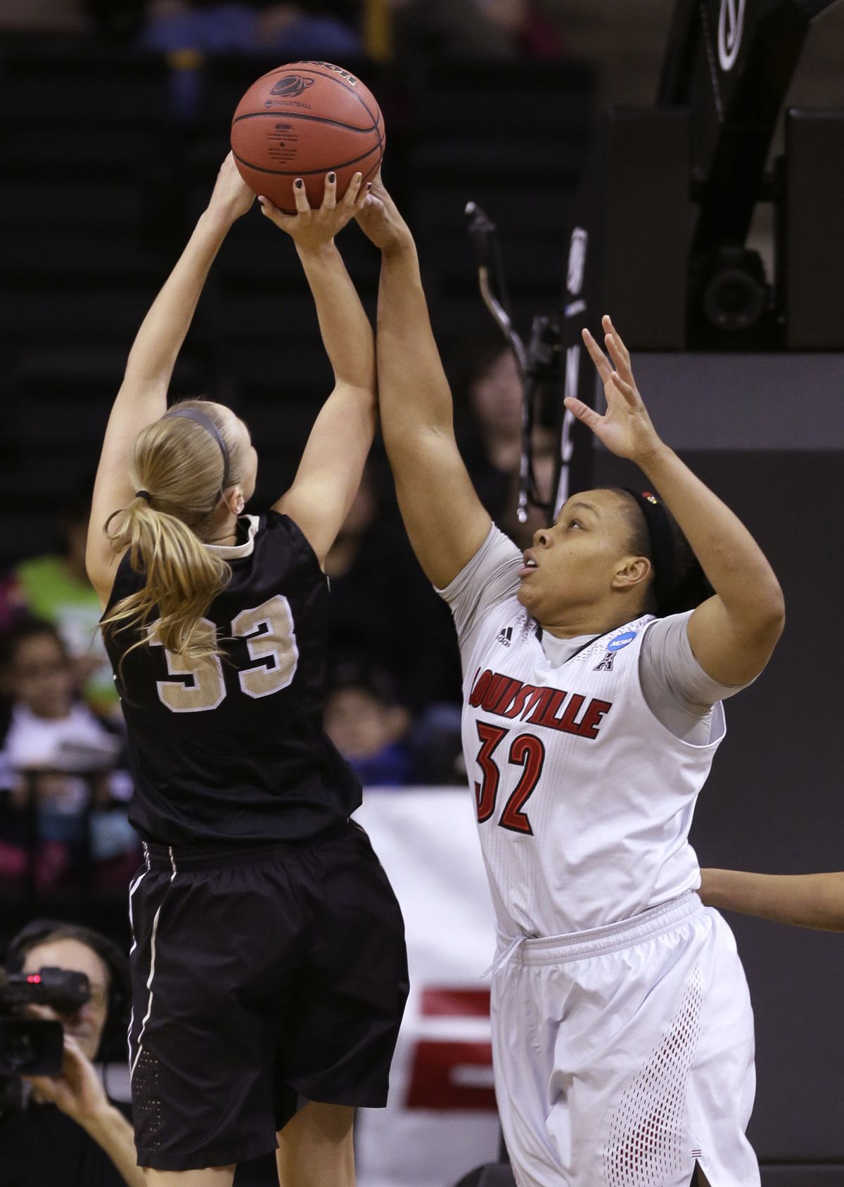Louisville forward Emmonnie Henderson, right, blocks a shot by Idaho forward Alyssa Charlston during the second half of an NCAA tournament first-round women