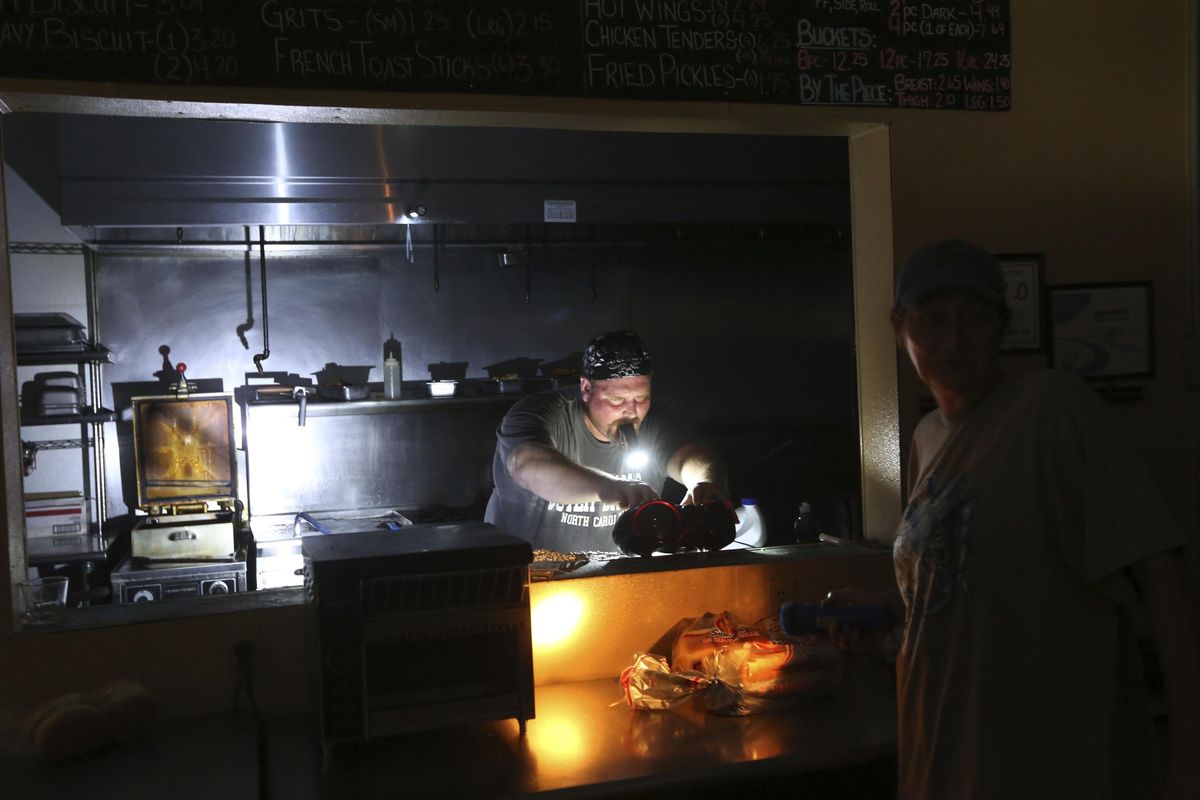 Aaron Howe cooks in the dark kitchen at the Island Convenience Store in Rodanthe on Hatteras Island, N.C., on Friday, July 28, 2017. (Steve Earley / AP)