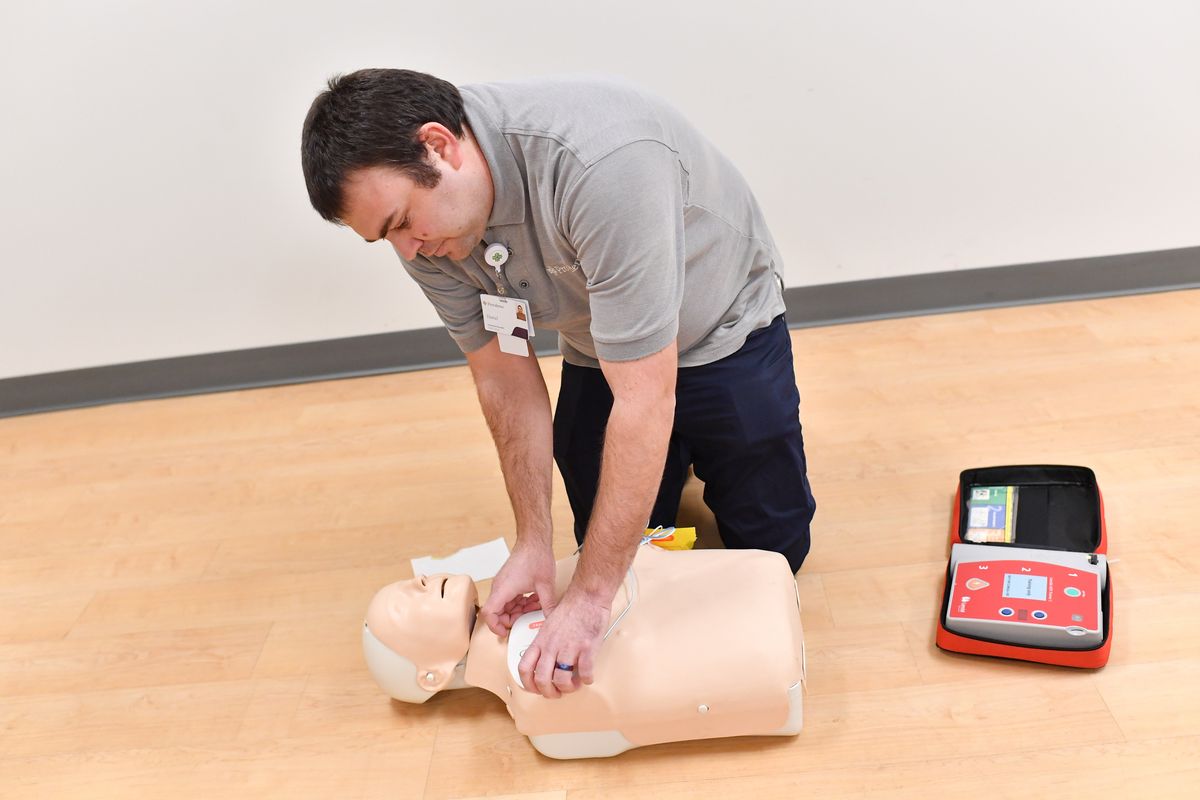 Paramedic Daniel Ingalls demonstrates how to use an AED Wednesday at Providence Health Training Center in Spokane. Ingalls emphasized the importance of proper chest compressions in addition to the AED and noted that two people, one performing CPR and the other deploying the AED, would be an ideal situation.  (Tyler Tjomsland/The Spokesman-Review)