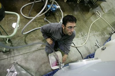 Dustin Tobin, the assistant winemaker at Thurston Wolfe Winery, pumps out some recently pressed fruit into steel barrels for fermenting on Nov. 11. Special to  (Kevin Quinn Special to / The Spokesman-Review)