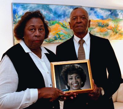 In this 1996 photo, Jessie and Robert Warr hold a photo of their slain daughter, Robin Warr Lawrence.  (Tom Allen/Washington Post)
