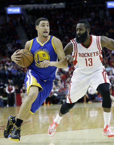 Golden State guard Klay Thompson, left, drives on Houston guard James Harden on Saturday. (Associated Press)