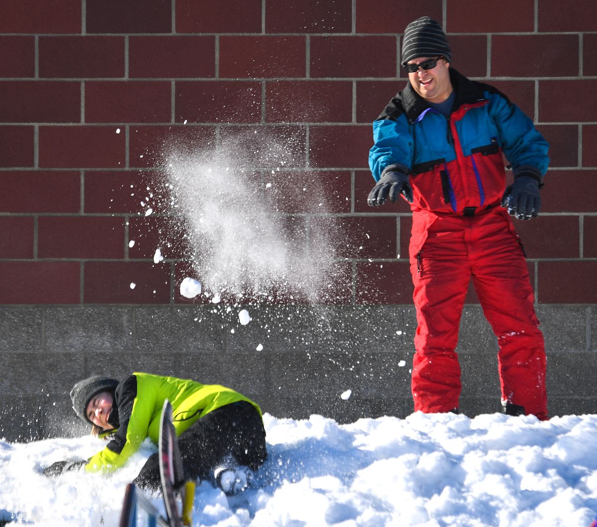Adrian Darrington, 49, gives some payback to his son, Zander, 13, as they engage in a snowball fight Saturday during an outing at Chase Middle School with the LDS Church 6 Ward in Spokane.  (DAN PELLE/THE SPOKESMAN-REVIEW)