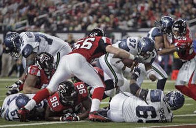 
Shaun Alexander (37) breaks through the line for his 100th career rushing touchdown in the first quarter.Associated Press
 (Associated Press / The Spokesman-Review)