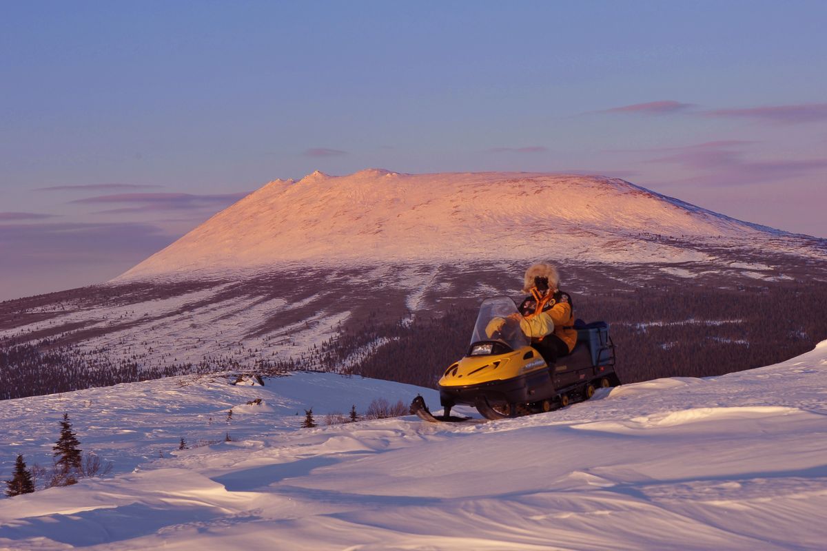 Josh Rindal pauses near Elim, Alaska, while snowmobiling along the Iditarod Trail. In the background is Little McKinley Mountain.