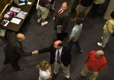 Spokane Valley Police Chief Cal Walker, lower center, shakes hands as his opponent in the race for Spokane County sheriff, former Spokane County Sheriff's Deputies Association President Ozzie Knezovich, looks on after a Spokane League of Women Voters candidate forum Thursday night.
(Jed Conklin / The Spokesman-Review)