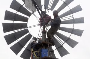 Hugh Grim, right, and Curt Henry, below left, check over the machinery of a 1933 windmill while mounting it on a new tower at Grim’s house on the western edge of Spokane on Saturday. Grim has refurbished three windmills, two of which are on his lawn.  (Photos by JESSE TINSLEY / The Spokesman-Review)