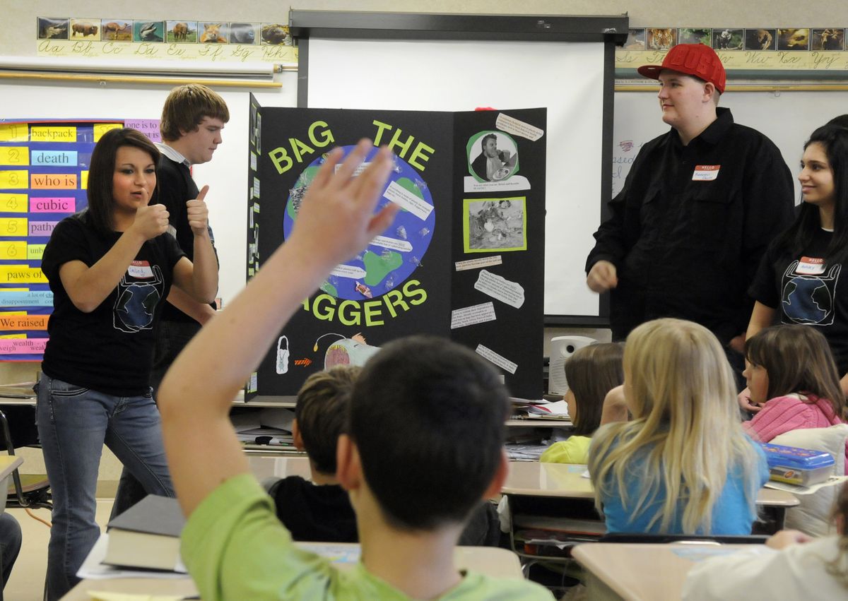 Emille Albritton, left, of M.E.A.D. Alternative School gives two thumbs up to Browne Elementary School during a presentation about using cloth shopping bags. Other M.E.A.D. Alternative students are Kevin Dennehy, back left, Keenen Davis, right, and Ashley Keen, far right.  (Photos by DAN PELLE / The Spokesman-Review)