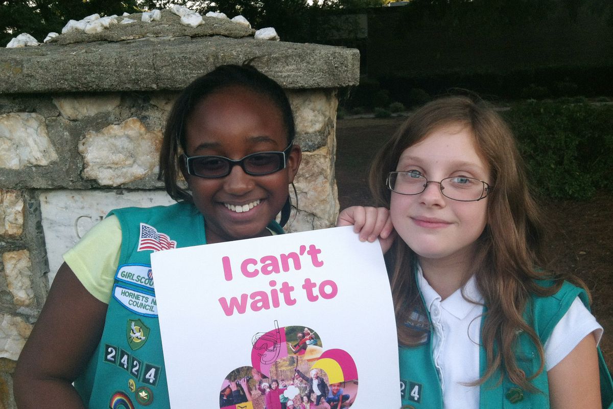 Natalie Harrison, left, and Jasmine Barnett of Troop 2424 hold a promotional poster for the Girl Scouts in Charlotte, N.C. (Associated Press)