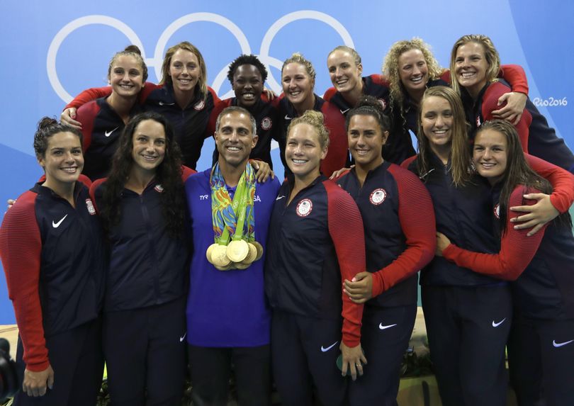 Members of the United States women’s water polo team with coach Adam Krikorian pose during the medals ceremony. (Sergei Grits / Associated Press)