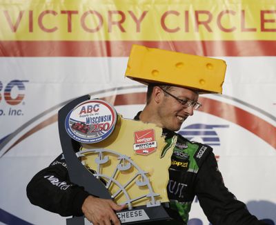 Sebastian Bourdais, of France, goes all Wisconsin with cheesehead and trophy after Sunday’s win. (Associated Press)