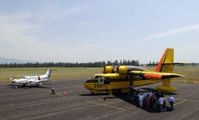 Media and representatives of the state Department of Natural Resources gather around a CL-215 firefighting plane at Deer Park Airport on Monday. 
 (Photos by Jesse Tinsley / The Spokesman-Review)