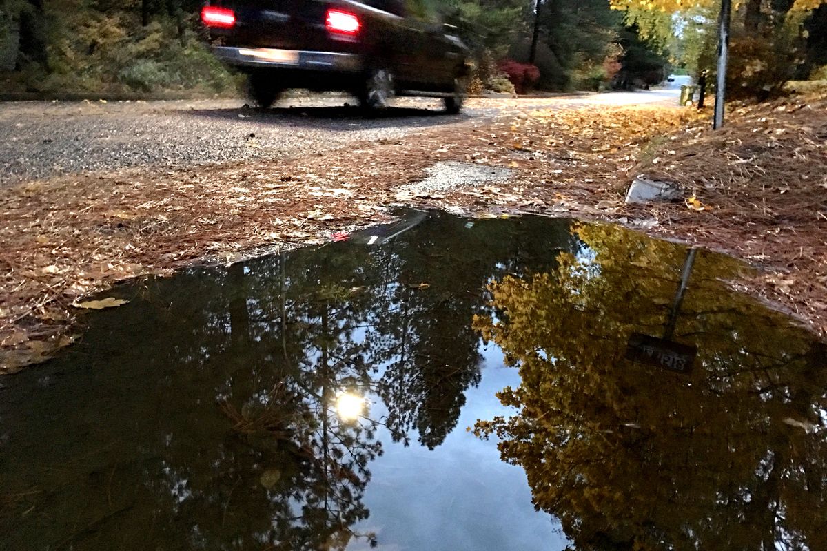 The world above is reflected in a puddle after heavy rains ended Oct. 31, 2016, pushing the rain total for a single month to a record 6.23 inches in Spokane.  (JESSE TINSLEY/The Spokesman-Review)