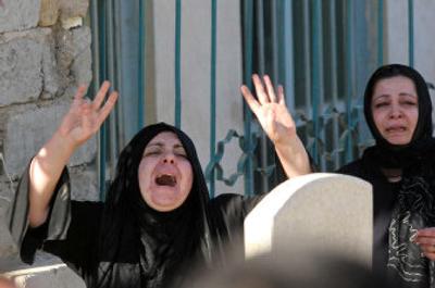 
Amjad Hamid's wife cries during his burial Saturday in Baghdad. Hamid, an Iraqiya state television journalist, and his driver were killed by unidentified gunmen Saturday. 
 (Associated Press / The Spokesman-Review)
