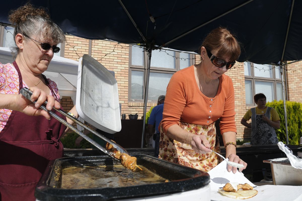 Nancy Despopoulos, left, and Theresa Callan make souvlakia, a shish kebab  served on pita bread with sauce, for visitors Saturday at the Holy Trinity Greek Orthodox Church’s annual Greek Festival dinner. The event is a major fundraiser for the church. (PHOTOS BY JESSE TINSLEY / The Spokesman-Review)
