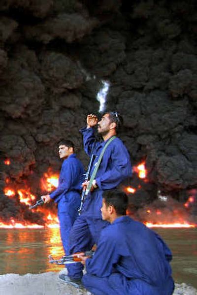 
Iraqi police watch a pipeline fire after an explosion near Beiji on Monday. 
 (Associated Press / The Spokesman-Review)