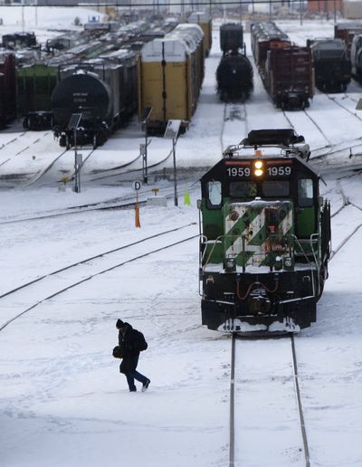 A worker walks across a BNSF rail yard in Kansas City, Kan., on Friday. A new railroad association report says cargo shipments were down sharply in 2009.  (Associated Press)
