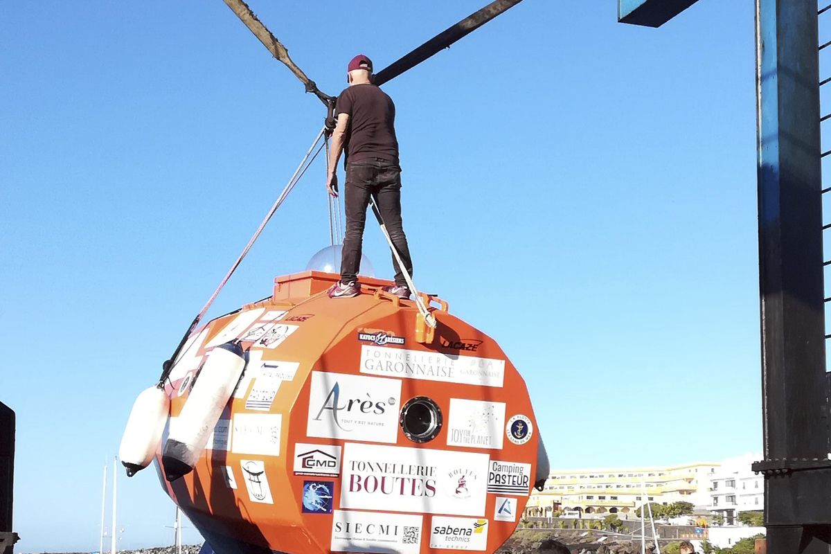 Frenchman Jean-Jacques Savin, 71-year-old, left, stands atop his 10-foot long, 7-foot wide resin-coated plywood capsule, which will use ocean currents alone to propel him across the sea Dec. 22, 2018. Savin set off from El Hierro in Spain’s Canary Islands on Wednesday and is aiming to complete his 2,800-mile journey to the Caribbean in about three months. (AP)
