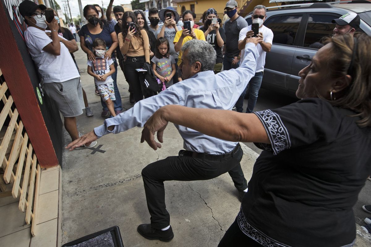 Fabio Rodolfo Vasquez and his wife, Maria Moreno, dance at a promotional event outside a coffee shop on the outskirts of Guatemala City on Sept. 19.  (Moises Castillo)
