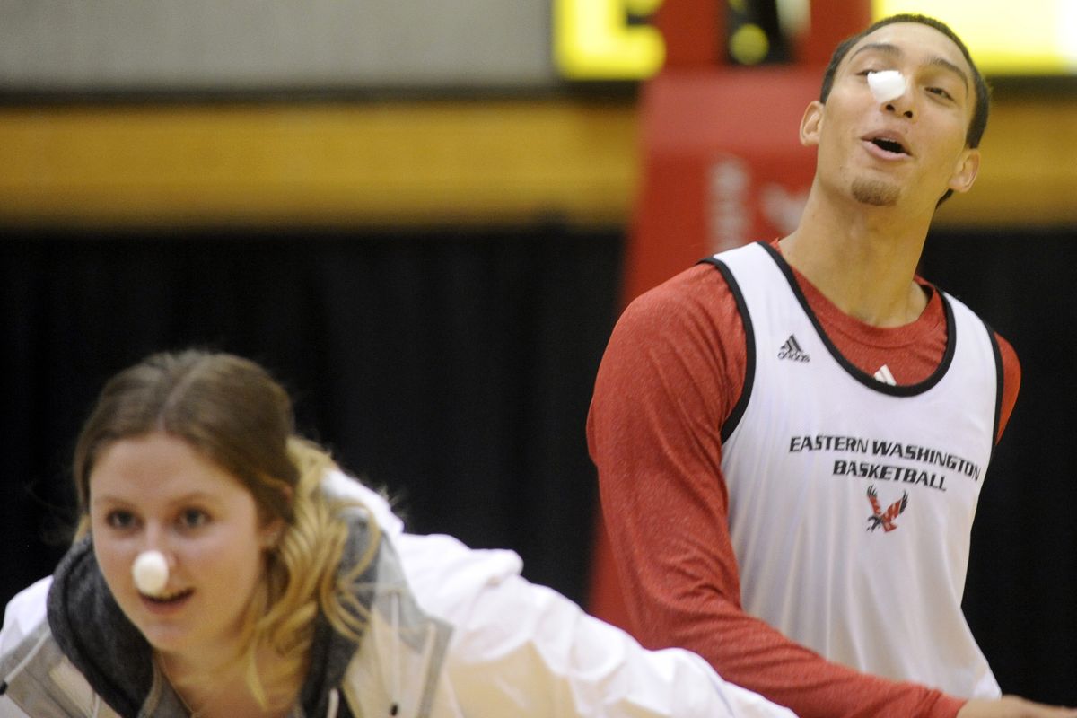 EWU’s Garrett Moon, right, tries to keep a cotton ball stuck to his nose in a relay race. (Jesse Tinsley)