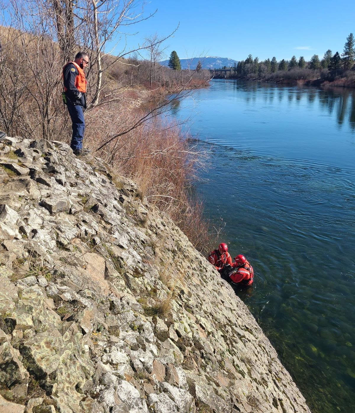 Spokane Valley Fire Department crew members wear swift water rescue gear to reach a dog that had fallen into the Spokane River near Plante’s Ferry Park on March 1. It had climbed on a ledge but couldn’t reach safety.  (SVFD Facebook page)
