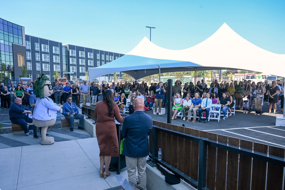 A crowd gathers to watch the ribbon cutting at the open house for the new CHAS Learning Institute, which opened for tours Thursday, Aug. 8, 2024 in the Iron Bridge development in Spokane, Washington. The school will train prospective medical assistants, dental assistants and pharmacy technicians.  (Jesse Tinsley/THE SPOKESMAN-REVIEW)