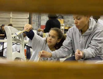 
Janay Nutter, 11, and mentor Tiffany Woody paint a chair that will eventually go in Janay's bedroom at the Space of Her Own, at the Art League Warehouse in Alexandria, Va. Organizers hope the young participants, all girls deemed to be 