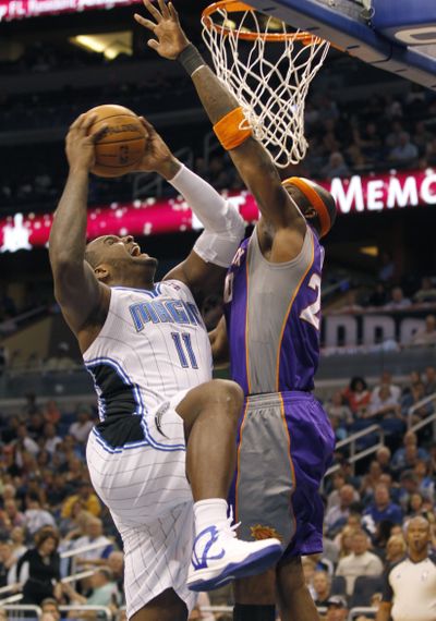 Orlando Magic forward Glen Davis, left, goes hard to the basket as Phoenix Suns center Jermaine O'Neal tries to block the shot. (Associated Press)