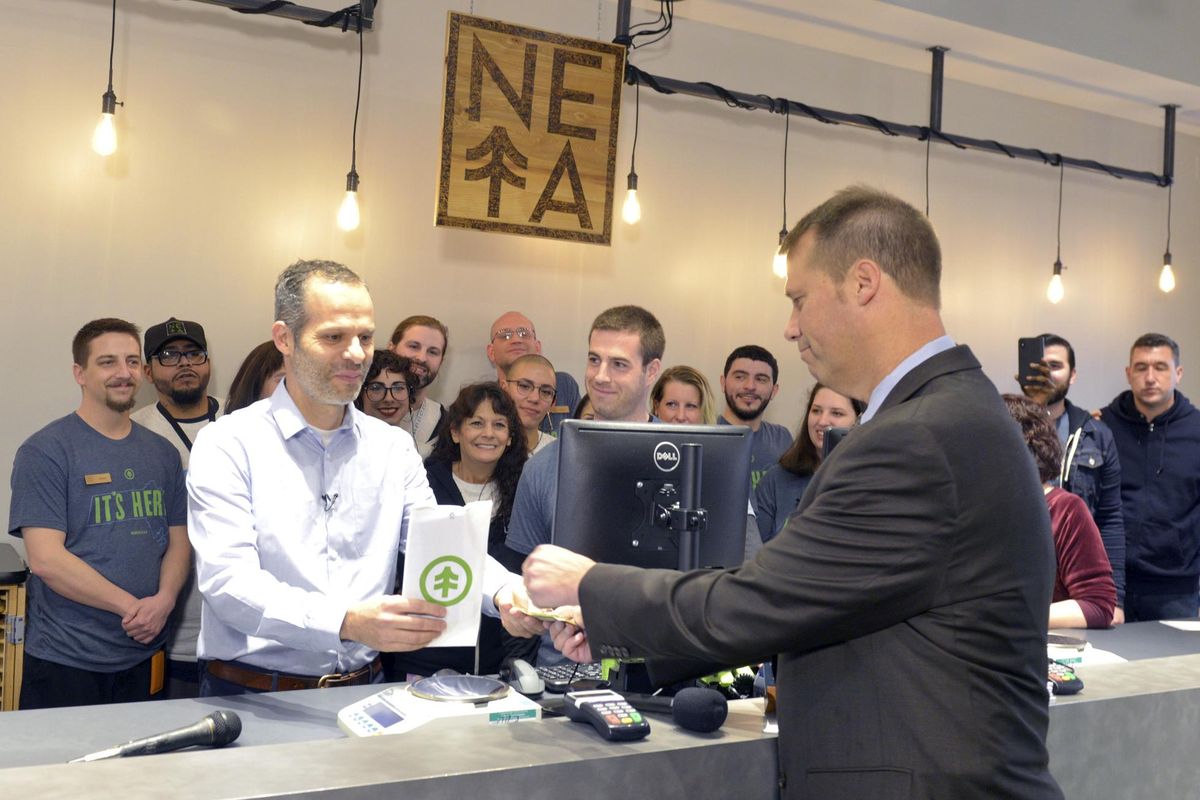 NETA co-founder Arnon Vered sells Northampton Mayor David Narkewicz the first legal recreational sale of marijuana at the NETA facility on Tuesday, Nov. 20, 2018, in Northampton, Mass. The state’s first commercial pot shops opened Tuesday in Leicester and Northampton. The stores are the first to operate on the East Coast of the U.S., and there were long lines at both locations. (Don Treeger / AP)