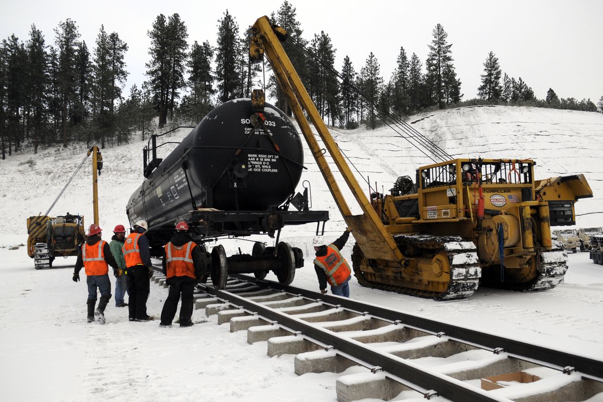 An out-of-service pressurized rail car is lowered onto its wheels with help from Hulcher Services employees Sunday at the Kootenai County Fire and Rescue District’s new training site on Seltice Way in Post Falls. BNSF railroad provided two rail cars, ties and tracks, along with the costs of decontaminating the cars.  (J. BART RAYNIAK)