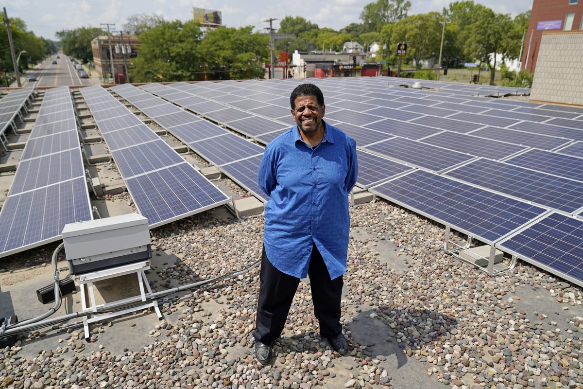 Bishop Richard Howell poses Aug. 19, 2021 beside some of the 630 solar panels on the roof of Shiloh Temple International Ministries in Minneapolis The church is one of many "community solar" providers popping up around the U.S. as surging demand for renewable energy inspires new approaches. Aug. 19, 2021, in Minneapolis.  (Jim Mone)