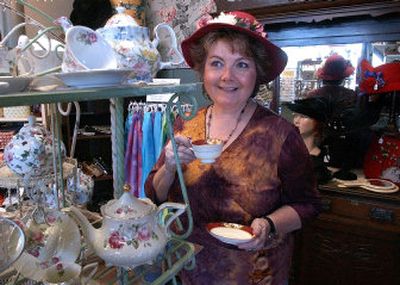 
Deborah Simpson shows off a flowered hat and one of the vintage tea cups available at Mad Hatties Boutique and Teas, which she owns with her mother Pat Croff. 
 (Liz Kishimoto / The Spokesman-Review)