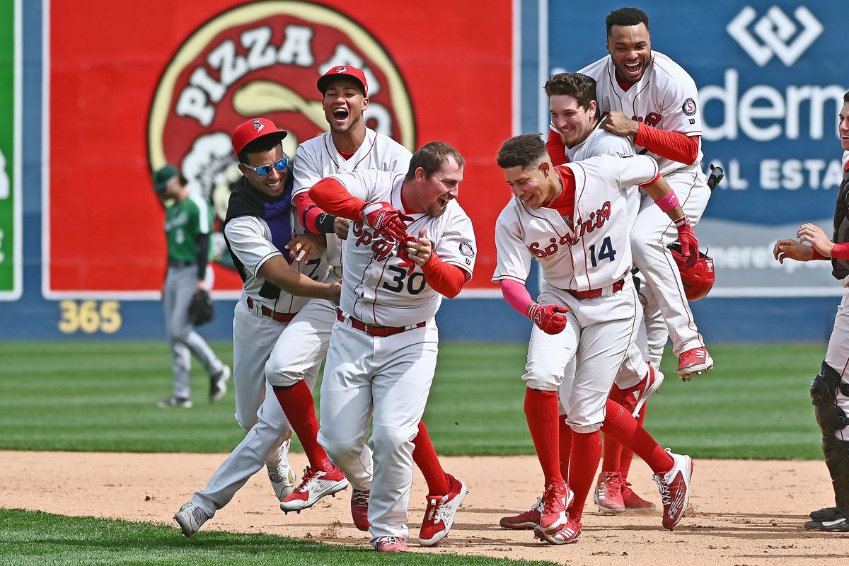 Spokane’s Colin Simpson (30) celebrates with teammates Tuesday after his 10th-inning single gave the Indians a 1-0 win over Eugene.  (James Snook)