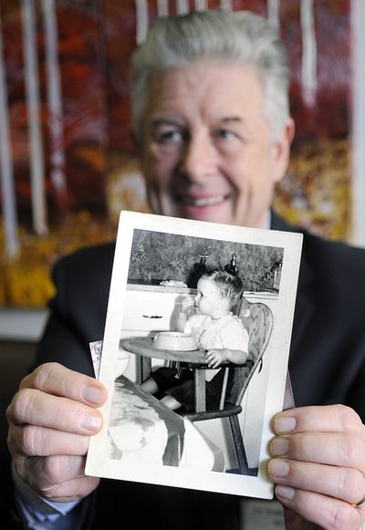 Spokane baby boomer Ed Clark, who will turn 65 in September, shows a photo of himself as a baby. The first boomers were born right after World War II. 