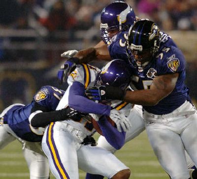 
Minnesota Vikings wide receiver Nate Burleson, center, is brought down by Baltimore Ravens linebacker Terrell Suggs and Deion Sanders, behind, during the first quarter of Sunday night's game. Minnesota was eliminated from playoff contention after the loss. 
 (Associated Press / The Spokesman-Review)