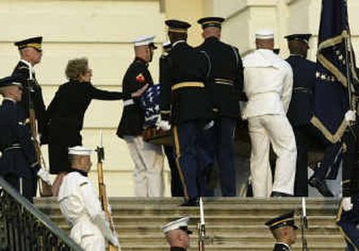 
Nancy Reagan reaches out to touch the flag-drapped casket of former President Ronald Reagan as it turns at top of the steps into the U.S. Capitol in Washington on Wednesday.
 (Associated Press / The Spokesman-Review)